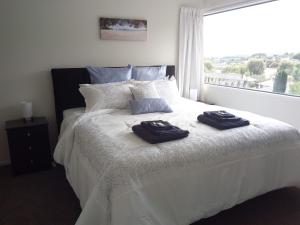 a bedroom with a bed with two towels on it at Super Sunny Holiday Home in Richmond