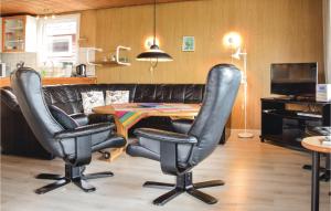 a living room with two chairs and a table at Holiday Home Ringvejen Rømø Iii in Rømø
