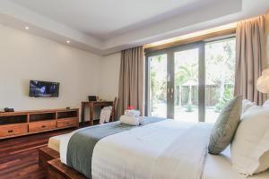 a bedroom with a large bed with a teddy bear on it at djabu Canggu Beach Villa in Canggu