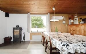 a dining room with a long table and a window at Holiday Home Ringvejen Rømø Iii in Rømø +8 photos