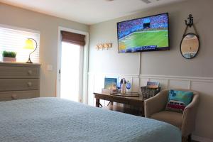 a bedroom with a bed and a tv on the wall at Latitude 26 Waterfront Boutique Resort - Bonita Springs in Bonita Springs