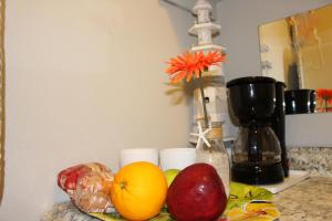 a counter with fruits and a vase with a flower at Latitude 26 Waterfront Boutique Resort - Bonita Springs in Bonita Springs