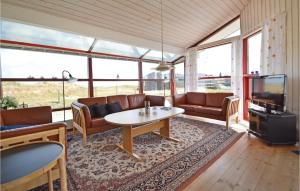a living room with a couch and a table at Holiday Home Kåverknoldene in Fanø