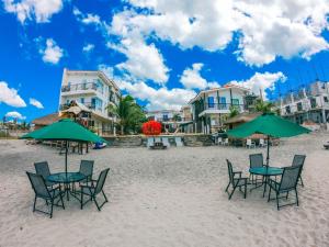 莫龍的住宿－Brisa Marina Beach Resort powered by Cocotel，海滩上的一组椅子和遮阳伞