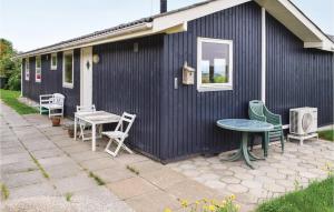 a blue building with chairs and a table on a patio at Three-Bedroom Holiday Home In Knebel in Knebel