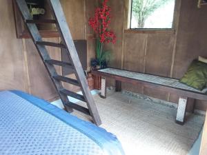 Habitación con escalera, cama y banco en The Bali Room en Coromandel Town