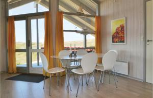 uma sala de jantar com uma mesa e cadeiras brancas em Amazing Home In Fan With Sauna em Sønderho