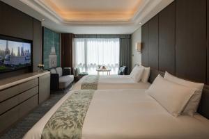 Ein Bett oder Betten in einem Zimmer der Unterkunft Oriental Riverside Bund View Hotel (Shanghai International Convention Center)