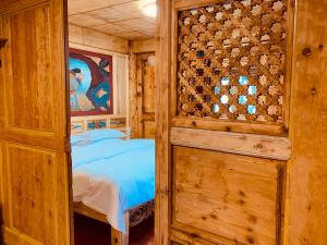 sypialnia z łóżkiem i drewnianą ścianą w obiekcie Shangri-La Xiangye Listen to the rain Hotel w mieście Shangri-La
