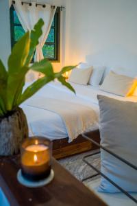 a bedroom with a bed with a candle on a table at Big Tree Boutique Hotel in Ko Tao