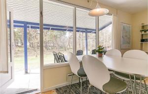 ein Esszimmer mit einem weißen Tisch und Stühlen in der Unterkunft Fyrreroden in Vester Sømarken + 7 Fotos