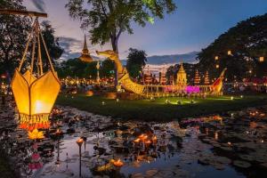 a night view of a pond with lights in a park at Vitoonguesthouse2fanrooms & Aircondition in Sukhothai
