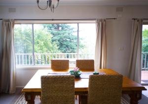 a living room with a table, chairs and a window at Healesville Apartments in Healesville