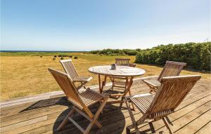 a patio with a table and chairs on a deck at Holiday Home Æblerosevej in Yderby