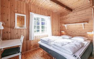 Cama en habitación de madera con ventana en Grshytten en Bedegård