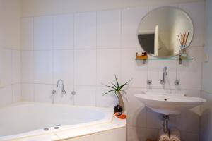a bathroom with a tub, sink and mirror at Healesville Apartments in Healesville