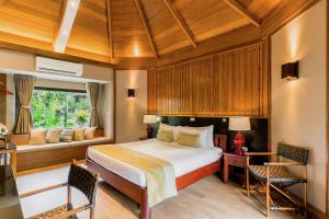 a bedroom with a bed and a window at River Kwai Resotel - SHA Extra Plus in Sai Yok