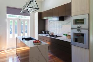 a kitchen with a refrigerator and a counter with a bowl of fruit at The Manse on Ebden in Kyneton