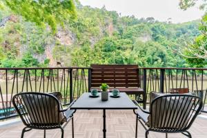 a patio with a table and two chairs and a bench at River Kwai Resotel - SHA Extra Plus in Sai Yok