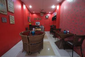 a restaurant with red walls and tables and chairs at Balai Carmela in Tuguegarao City