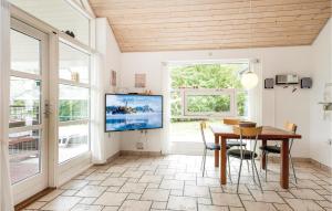 HelberskovにあるAmazing Home In Hadsund With 5 Bedrooms, Sauna And Wifiのダイニングルーム(テーブル、テレビ付)