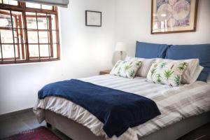 a bedroom with a bed with a blue blanket on it at Springbank Guest Suite in Johannesburg