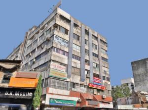 a tall building on the side of a street at HOTEL OSTRIA in Surat