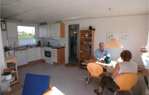 a man and a woman sitting at a table in a kitchen at Mindegården in Hejls