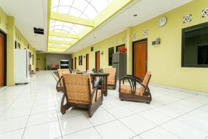 un pasillo con mesa y sillas en un edificio en RedDoorz Syariah near Assalaam - UMS, en Solo