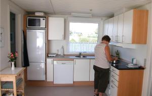 a woman standing in a kitchen with a sink at Mindegården in Hejls