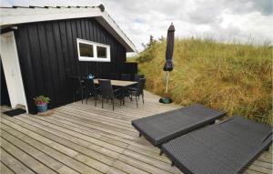 a wooden deck with chairs and a table and an umbrella at Holiday Home Harrietsvej in Grønhøj