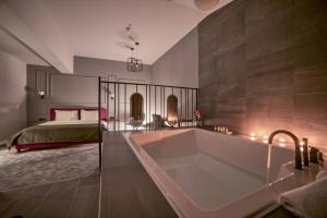 a large bathroom with a tub and a bed at Boscovich Boutique Hotel in Podgorica