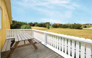 a wooden deck with a wooden bench on a house at Holiday Home Hvide Sande 48 in Bjerregård