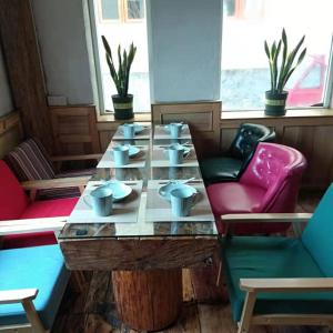 stół z kubkami w pokoju z krzesłami w obiekcie Shangri-La Xiangye Listen to the rain Hotel w mieście Shangri-La