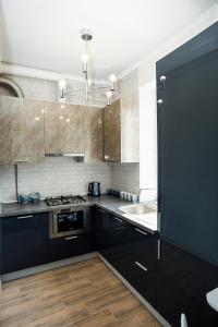 a kitchen with black cabinets and a sink at Квартира в центре для гурманов стиля in Chernihiv