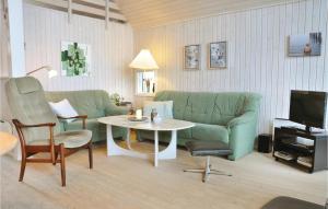 a living room with a green couch and a table at Holiday Home Asperup 55 in Asperup