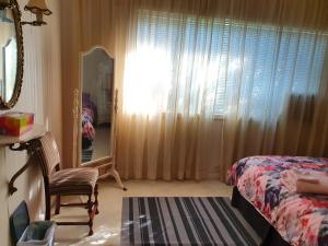 a bedroom with a bed and a window with curtains at Airport HomeStay in Perth