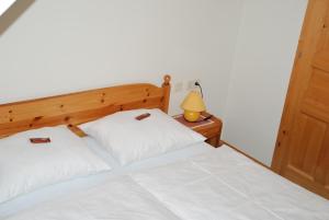 a bedroom with two beds with white sheets and a lamp at Ferienwohnung Lahnerhof in Arriach