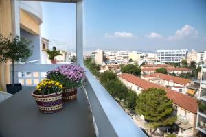 3 Topfpflanzen auf einem Balkon mit Stadtblick in der Unterkunft Boutique Penthouse next to Stavros Niarchos Foundation in Athen