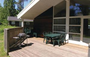 una terraza con parrilla, mesa y sillas en Rubinsen Skovhus, en Hasle