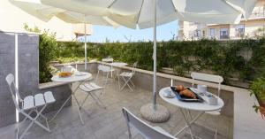 a patio with tables and chairs and an umbrella at Best Vasto in Vasto