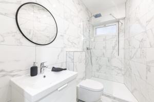 een witte badkamer met een wastafel en een spiegel bij STRASBOURG HYPER CENTRE 2P de 30m2 in Straatsburg +15 foto's