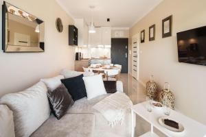 una sala de estar con un sofá y una mesa en Apartament GOLD Gardenia Dziwnów, en Dziwnów