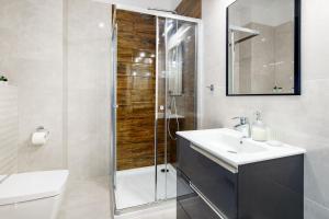 Un baño con lavabo y ducha en Apartament GOLD Gardenia Dziwnów, en Dziwnów 29 fotos más