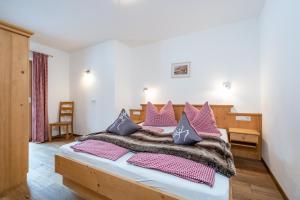 1 dormitorio con 1 cama grande con almohadas rosas y moradas en Appartement Einödberg, en Mittersill