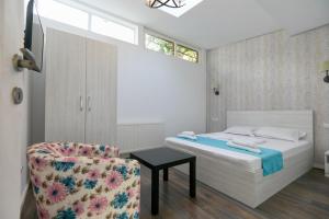 a bedroom with a bed and a chair at Stanford apartments in Bucharest