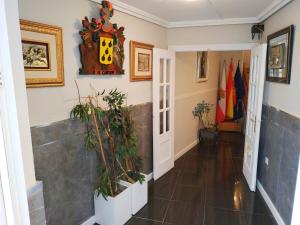 a hallway with plants and a clock on the wall at Hotel Canton in San Vicente de la Barquera