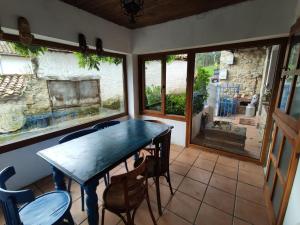 a dining room with a blue table and chairs at El Cuetu in Posada