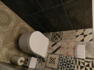 a bathroom with a toilet and tiles on the wall at Klassik and sunny Apartment! in Vienna