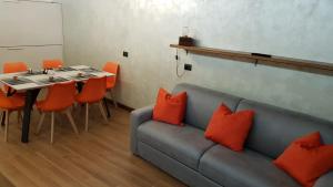a living room with a couch and a table with orange pillows at Orange Fox Cervinia apartment Vda Vacanze in Vetta CIR 0185 in Breuil-Cervinia